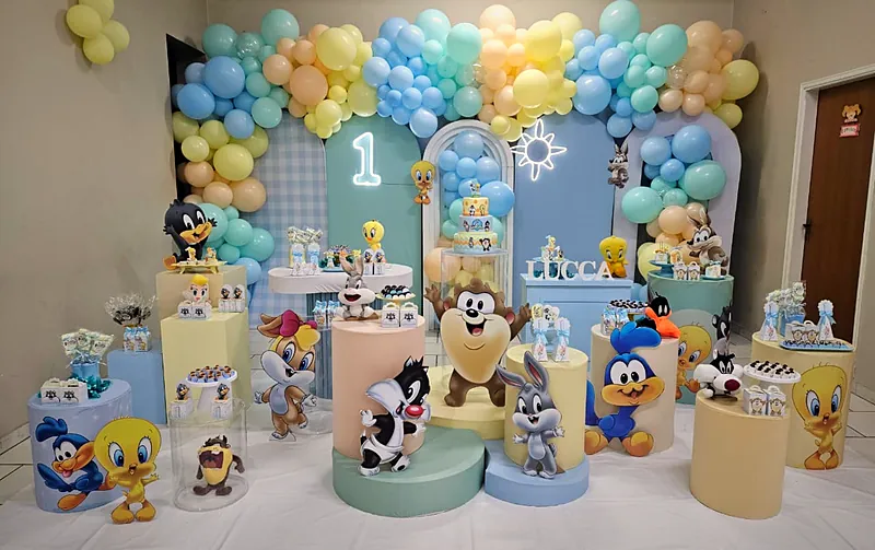 Mesa do bolo tema Baby Looney Tunes com balões azul, amarelo e verde-água